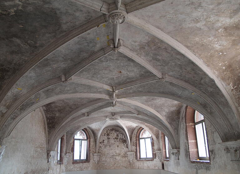 Kapitelsaal mit Rippengewölbe und (hinten) polygonaler Apsis mit dem Wappen des Erbauers Fürstbischof Julius Echter im Zentrum. Das Bild zeigt den Zustand während der Renovierung im August 2020.