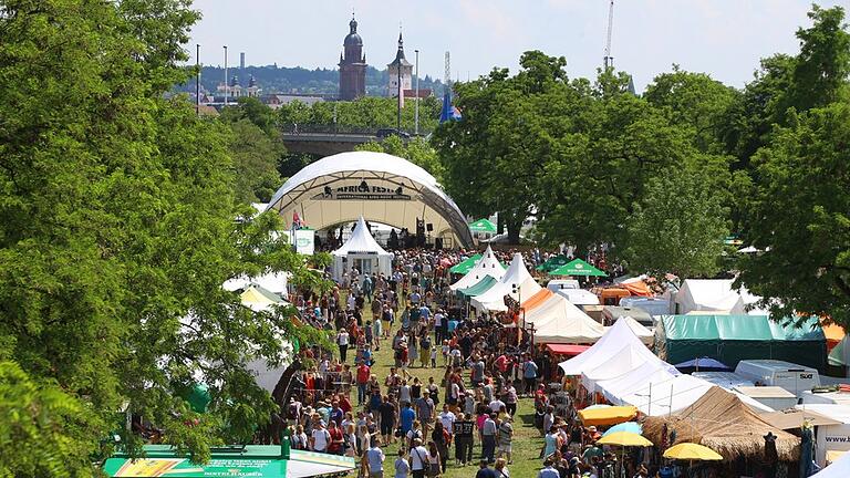 Würzburger Africa-Festival       -  Besucher des Africa-Festivals laufen über das Gelände am Main.