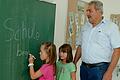 Die Schülerinnen Lenia und Malina probieren schon einmal die neue Tafel in der neuen Thüngener Grundschule aus. Bürgermeister Lorenz Strifsky schaut ihnen dabei über die Schulter.