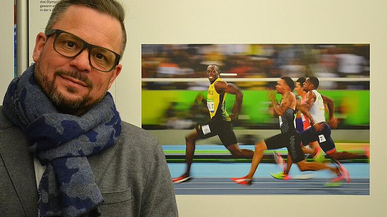 World-Press-Photo-Gewinner Kai Pfaffenbach neben seinem Siegerfoto von Usain Bolt bei den Olympischen Spielen 2016 in Rio de Janeiro.