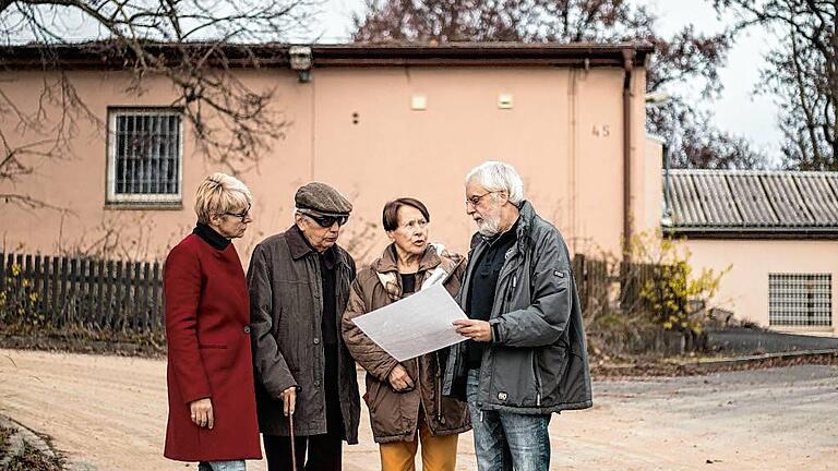 Roland Flade (rechts) erklärt Antoine Gorceix und seiner Gattin Marie-Josephe das Areal unterhalb der ehemaligen NS-Flugschule am Hubland, wo sich einst das Gefangenenlager für die französischen Soldaten befand, links LGS-Geschäftsführerin Claudia Knoll.