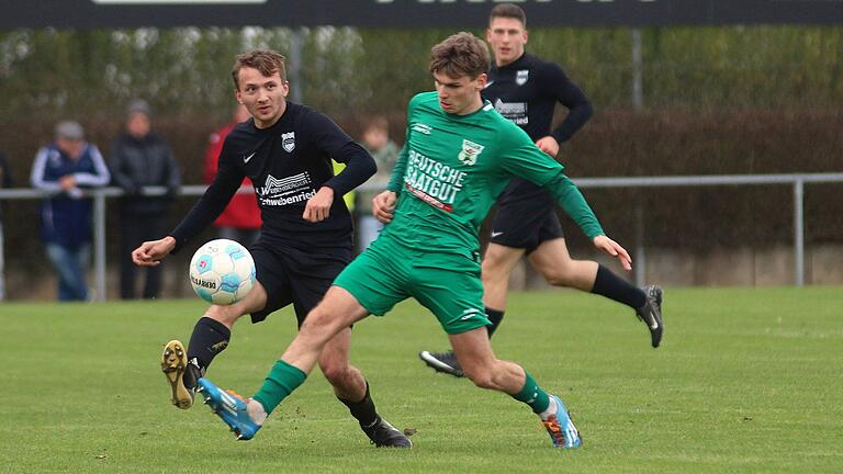 Außenverteidiger Lucas Schneider (links) von der DJK Schwebenried/Schwemmelsbach passt den Ball, sein Gegenspieler Julius Landeck vom TSV Großbardorf kam einen Schritt zu spät.