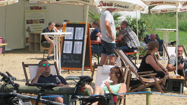 Chillen und sonnen bei Cocktails, Snacks und Hammelburger Wein lockte bereits zahlreiche Besucher an den neu geschaffenen Saalestrand.  Foto: Winfried Ehling       -  Chillen und sonnen bei Cocktails, Snacks und Hammelburger Wein lockte bereits zahlreiche Besucher an den neu geschaffenen Saalestrand.  Foto: Winfried Ehling