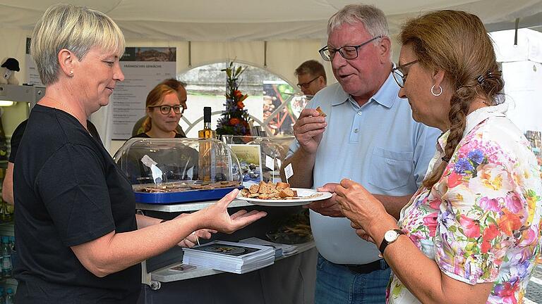 Eva Kalla (links) war nicht nur als zweite Bürgermeisterin Fladungens beim Genussfestival. Als Hauswirtschaftsmeisterin hat sie sich mit den Erzeugern Josef Kolb und Friedhelm Ortlepp um die Zubereitung der Probierhäppchen gekümmert. Hier reicht sie Georg und Irene Firnkäs aus Pfaffenhofen Kostproben. Organisatorin Kathrin Wimmer beobachtet die Szene
