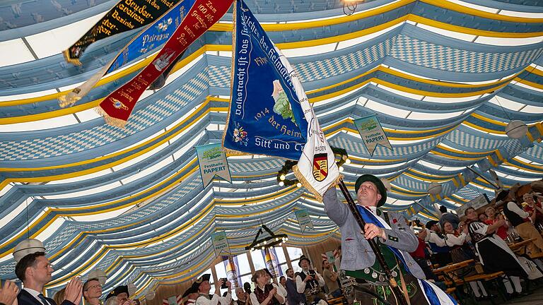 Mit dem traditionellen Fahnenschwingen wurden am Samstag in Schweinfurt im Volksfestzelt das Gautrachtenfest eröffnet. Landrat Florian Töpper (von links) und Oberbürgermeister Sebastian Remelé klatschten begeistert Applaus.