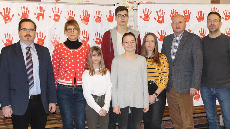 Gedenkstunde zum Red Hand Day (von links): Schulleiter Ingo Schneider, Verena Kieslich, Zoe Fasel, Jan Knes, Luisa Küber, Celina Dittloff, Abgeordneter Bernd Rützel und Jürgen Endres.