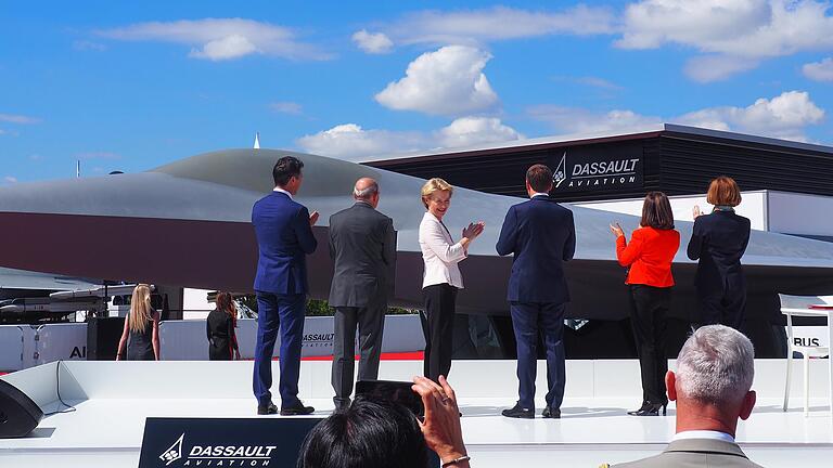Bei der Präsentation eines Modells des neuen europäischen Kampfjets in Le Bourget bei Paris steht Verteidigungsministerin Ursula von der Leyen (Dritte von links) neben Präsident Emmanuel Macron.