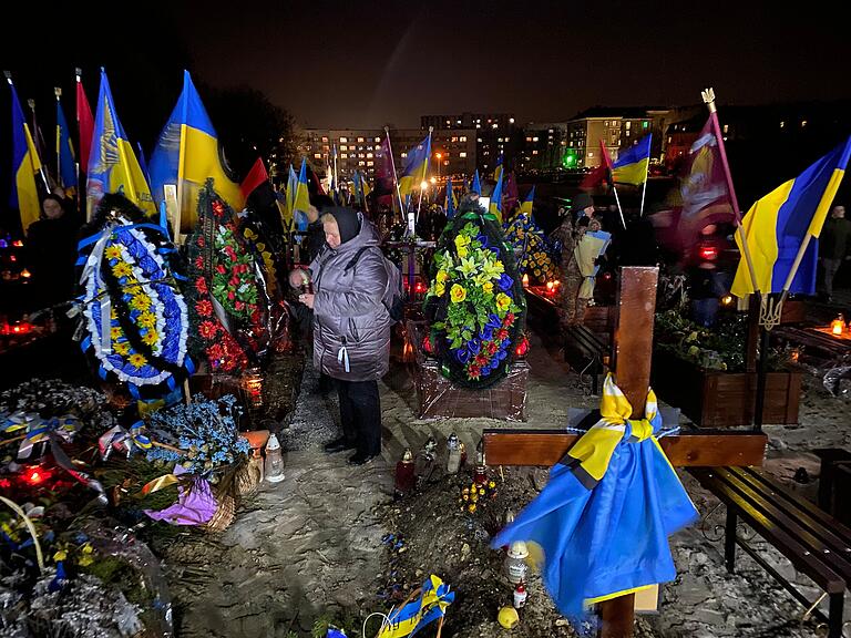 Beim Gedenken an die Gefallenen des Ukraine-Krieges zündet eine Frau eine Kerze an. Beim Gedenken an die Gefallenen des Ukraine-Krieges zündet eine Frau eine Kerze an.