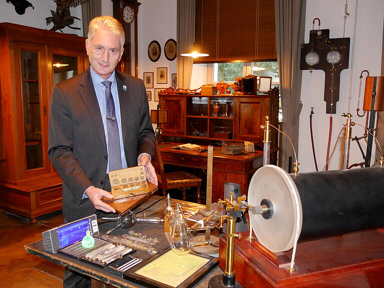 Roland Weigand am originalen Schauplatz der Entdeckung in der heutigen Röntgen-Gedächtnisstätte am Röntgenring 8. In der Hand hält er die Bleigewichte, die der Forscher zuerst abbildete. Roland Weigand am originalen Schauplatz der Entdeckung in der heutigen Röntgen-Gedächtnisstätte am Röntgenring 8. In der Hand hält er die Bleigewichte, die der Forscher zuerst abbildete.