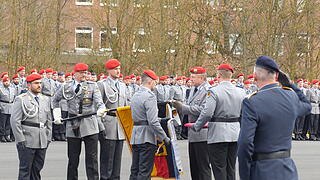 Regimentskommandeur Matthias Kampf (Dritter von rechts) übergibt dem Bataillonskommandeur Manuel Goldschmitt (gegenüber) das Fahnenband.