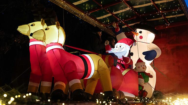 Weihnachtstrucks       -  Rund 120 geschmückte Weihnachtstrucks stehen am Freitag (22.12.23) in der  Kleinen Au in Karbach (Lkr. Main-Spessart). Zahlreiche Menschen nutzen die Gelegenheit, um sich die Fahrzeuge anzusehen, bevor sich der Konvoi auf den Weg macht.