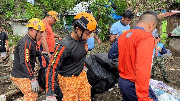 Nach dem Tropensturm Trami auf den Philippinen - Rettungskräfte bergen eine Leiche nach einem Erdrutsch, der durch den Tropensturm Trami ausgelöst wurde Nach dem Tropensturm Trami auf den Philippinen - Rettungskräfte bergen eine Leiche nach einem Erdrutsch, der durch den Tropensturm Trami ausgelöst wurde