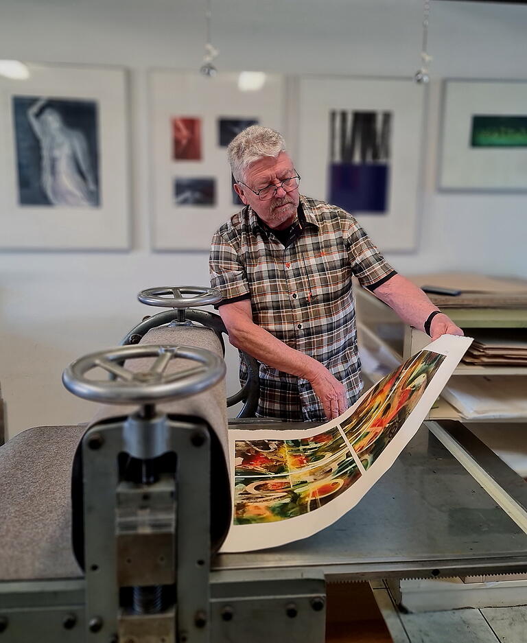 Dieter Kraft begutachtet einen Druck an der Druckpresse. Dieter Kraft begutachtet einen Druck an der Druckpresse.