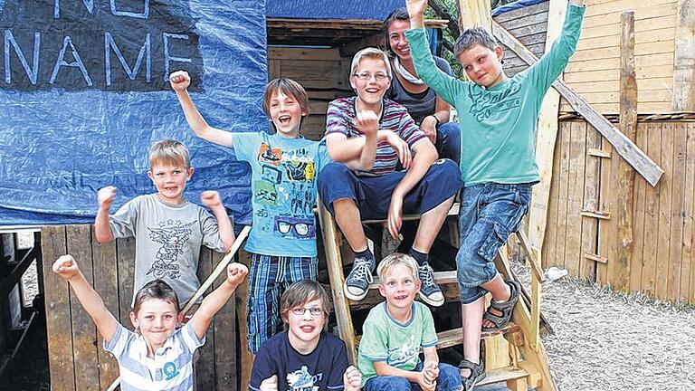 Stolz wie Bolle: Tobias, Michael, Julius, Leon, Florian, Andreas und Jeremias mit ihrer Betreuerin Ann-Sophie sind stolz auf ihre selbstgebaute Hütte mit integrierter Schiebetür.