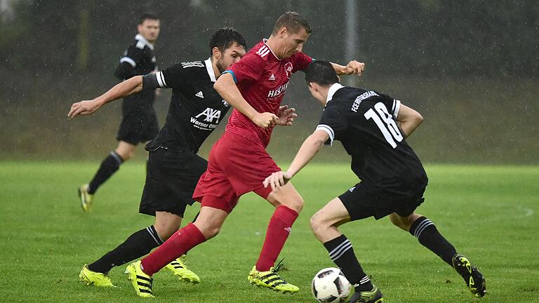 Florian Zirkelbach (Mitte) marschierte mit dem TSV Bad Königshofen im strömenden Regen gegen den FC Rottershausen (links Frank Seufert, rechts Martin Schmitt) ins Halbfinale des Toto-Pokals.