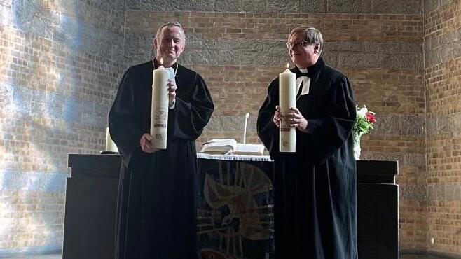 Landesbischof Christian Kopp (links) und Leitender Bischof Dr. Támas Fabiny präsentieren beim Abschlussgottesdienst in St. Johannis die Partnerschaftskerzen.