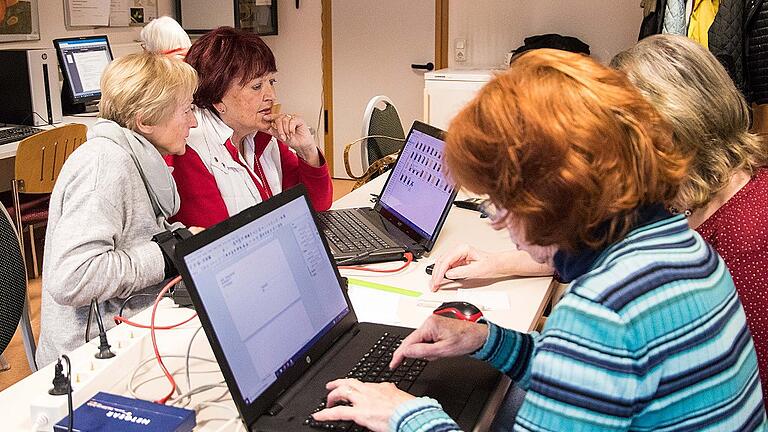 Die Damen helfen sich im Internetcafé  des Caritas Seniorenzentrums St. Thekla gegenseitig beim Erkunden der digitalen Welt.