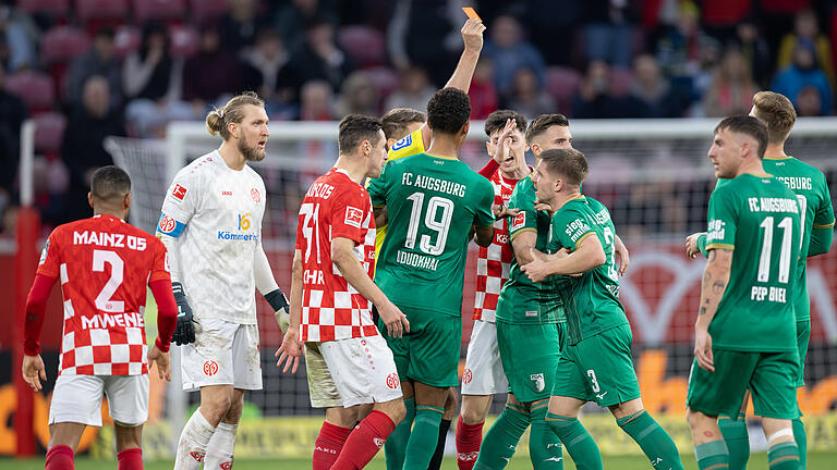 FSV Mainz 05 - FC Augsburg.jpeg       -  FSV Mainz 05 - FC Augsburg 17.02.2024, Rheinland-Pfalz, Mainz: Fußball: Bundesliga, FSV Mainz 05 - FC Augsburg, 22. Spieltag, Mewa Arena. Die Spieler beider Teams bilden ein Rudel während Schiedsrichter Tobias Reichel Augsburgs Mads Pedersen die Rote Karte zeigt. Foto: Jürgen Kessler/dpa - WICHTIGER HINWEIS: Gemäß den Vorgaben der DFL Deutsche Fußball Liga bzw. des DFB Deutscher Fußball-Bund ist es untersagt, in dem Stadion und/oder vom Spiel angefertigte Fotoaufnahmen in Form von Sequenzbildern und/oder videoähnlichen Fotostrecken zu verwerten bzw. verwerten zu lassen. +++ dpa-Bildfunk +++