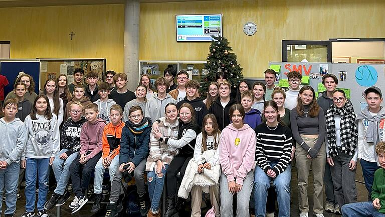 Die Teilnehmenden am Klassensprecherseminar zusammen mit ihren Vertrauenslehrkräften Eva Burkard und Mario Heß vor dem geschmückten Weihnachtsbaum der SMV im Forum des LSH.