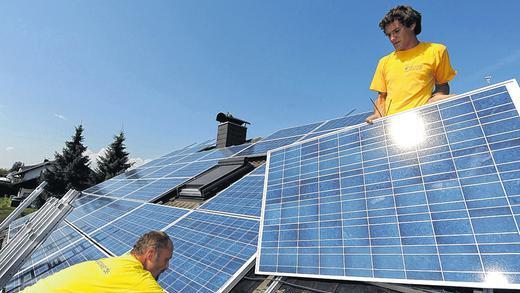 Umstrittene Energiegewinnung: Solartechniker installieren auf einem Dach in Frittlingen (Zollernalbkreis) Solarpaneele.