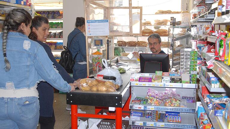 Geschäftsführer Arif Kille (rechts) an der Kasse seines Supermarkts Pazar in der Kitzinger Kaiserstraße mit Kundinnen. Geschäftsführer Arif Kille (rechts) an der Kasse seines Supermarkts Pazar in der Kitzinger Kaiserstraße mit Kundinnen.