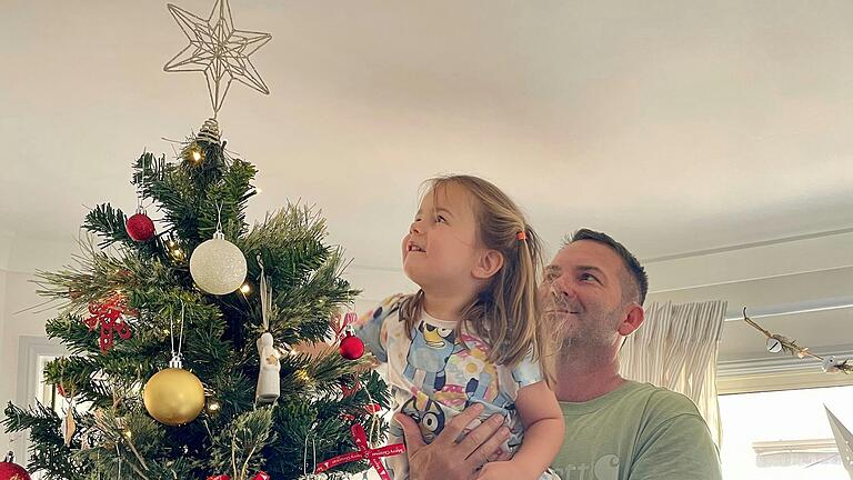 Ehemann Quinn und Tochter Pippa beim Schmücken des Weihnachtsbaums. Ehemann Quinn und Tochter Pippa beim Schmücken des Weihnachtsbaums.