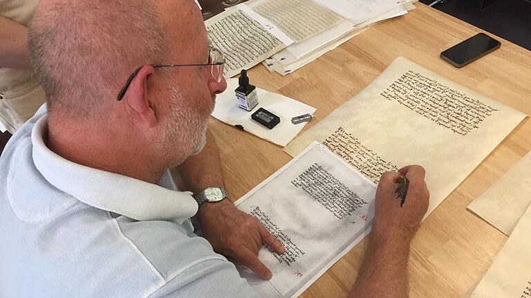 Der Karlstadter Kalligraf Gosbert Stark schreibt für die Ausstellung 'Kairos' einen griechischen Text im Stile des 14. Jahrhunderts auf ein Pergament.