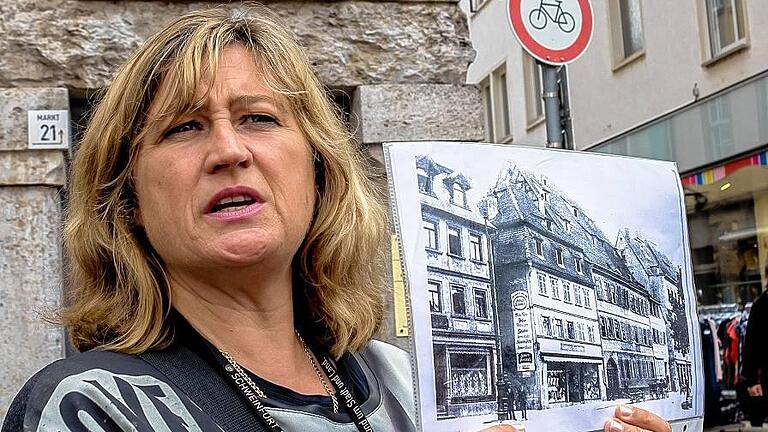 Hier stand das Gasthaus zum Raben: Martina Barth zeigt ein historisches Foto an historischem Ort. Überdauert haben nur die Arkaden des Hauses am Markt.