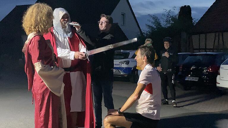 Serhii Popov wird nach seinem Zieleinlauf zum Ritter des Taubertal 100 Ultramarathons geschlagen.