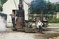 Das Bild aus dem Jahr 1963 zeigt das Gerät zum Kartoffeldämpfen, die sogenannte Dampfkolonne, in vollem Betrieb. Daran waren drei Kessel zum Kartoffeldämpfen. Der Mann auf dem Bild ist Kolonnenführer Erich Kempf und der Bub der siebenjährige Bernd Günther.