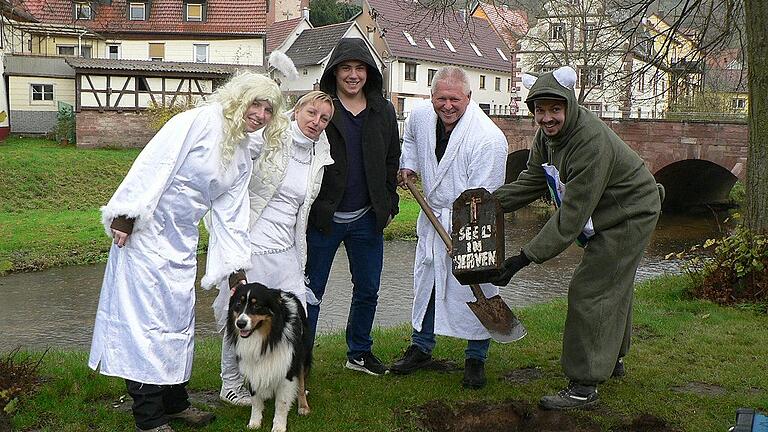 Narren graben den Fasching wieder aus       -  Die Tradition den Fasching am 11.11. um 11:11 Uhr auszugraben, haben der Präsident des modernen Chores &bdquo;ma so ma so&ldquo;, Ernst Reinhart, und einige Chormitglieder nach 15 Jahren wieder aufleben lassen. Am Faschingsdienstag hatten sie den Fasching in einem kleinen schwarzen Holzsarg hinter dem Kriegerdenkmal beerdigt. Nun waren alle voller Spannung, was der Präsident denn damals vergraben hatte. Heraus kam eine unversehrte Flasche Ouzo. Mit Bier, Glühwein, Knabbereien und Musik begingen sie die neue Session, die am Faschingsdienstag, 13. Februar 2018, endet. Wegen des anhaltenden Regens verlegten die Faschingsnarren ihre Feier unter die Überdachung der Bushaltestelle.