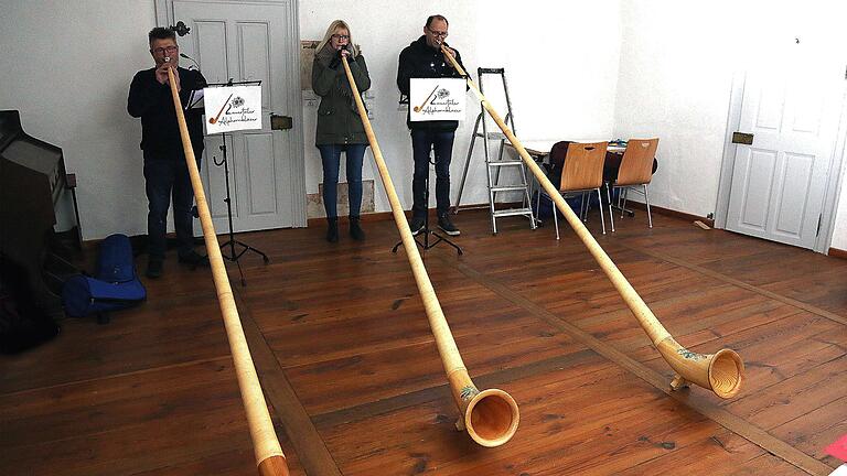 Drei der vier Mitglieder der Gruppe 'Lauertaler Alphornbläser' spielten  beim offiziellen Start des Adventskalenders im Münnerstädter Heimatspielhaus. Foto:  Dieter Britz       -  Drei der vier Mitglieder der Gruppe 'Lauertaler Alphornbläser' spielten  beim offiziellen Start des Adventskalenders im Münnerstädter Heimatspielhaus. Foto:  Dieter Britz