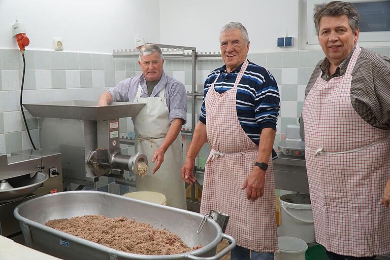 von links: Dieter Laut, Altbürgermeister Alfred Frank und Johannes Wagenpfahl mahlen die gekochte Schweinescharte mit Zwiebeln durch den Fleischwolf von links: Dieter Laut, Altbürgermeister Alfred Frank und Johannes Wagenpfahl mahlen die gekochte Schweinescharte mit Zwiebeln durch den Fleischwolf