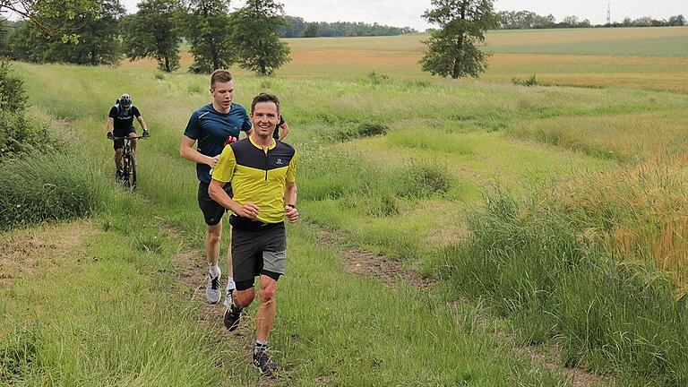 Gut gelaunt durch die grüne Landschaft der Hochrhön: Daniel Richter (vorne) und Julian Trabert. Begleitet werden sie auf dem Rad von Jochen Rüttiger.