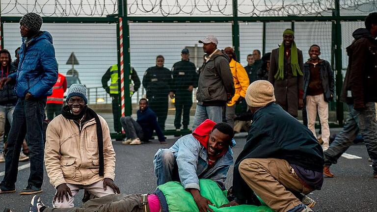 FRANCE-BRITAIN-EUROPE-MIGRANTS       -  Migrants are pictured on the Eurotunnel site near the boarding docks in Coquelles near Calais, northern France, on late July 29, 2015. One man died Wednesday in a desperate attempt to reach England via the Channel Tunnel as overwhelmed authorities fought off hundreds of migrants, prompting France to beef up its police presence. AFP PHOTO / PHILIPPE HUGUEN