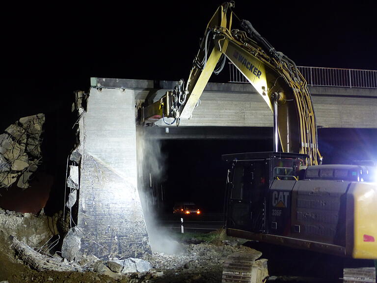 Der erste Bagger hämmert Löcher in das Betonwerk Der erste Bagger hämmert Löcher in das Betonwerk