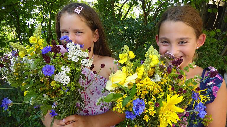 Mit den bunten Kräuterbüscheln, die (von links) Anna und Sophia in den Armen halten, wird an 'Maria Himmelfahrt' der  uralte Brauch der Kräuterweihe gepflegt.