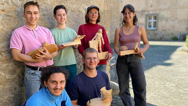 Künstler (entsendende Schnitzschule) und Werke von links stehend: Noel Pruschwitz (Empfertshausen), Sarah Riedißer (Kloster Wald), Lena Stegemann (Bischofsheim/Rhön), Emma Heckl (Oberammergau), knienend: Damian Jung (Freiburg), Johannes Fischer (Garmisch Partenkirchen).