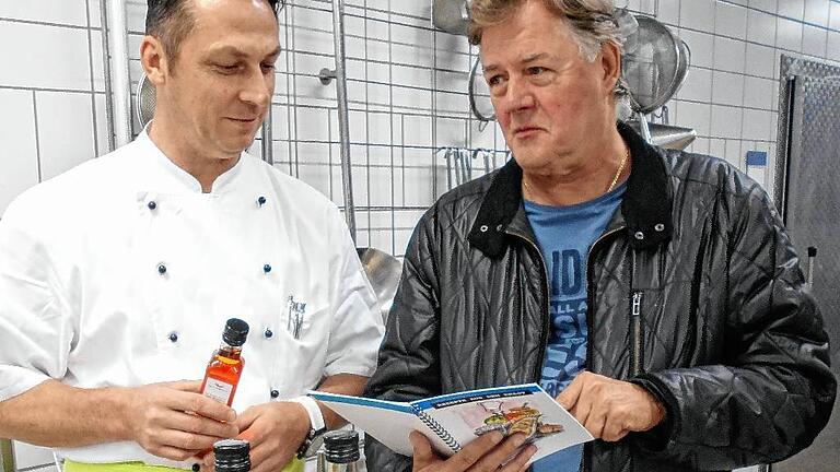 Das Genuss-Paket war eine Idee von Roland Hell (links), Chef der Würzburger JVA-Küche. Reinhold Müller hat die Rezeptsammlung von Gefangenen illustriert.