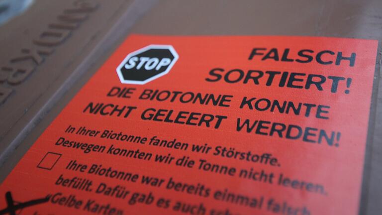 Mitarbeiter einer Fachfirma kontrollieren in Kitzingen Biotonnen auf Abfall, der darin nichts zu suchen hat. Tonnen, deren Inhalt dem einer Restmülltonne gleicht, werden mit roten Aufklebern versehen. Sie bleiben stehen und werden nicht geleert. Mitarbeiter einer Fachfirma kontrollieren in Kitzingen Biotonnen auf Abfall, der darin nichts zu suchen hat. Tonnen, deren Inhalt dem einer Restmülltonne gleicht, werden mit roten Aufklebern versehen. Sie bleiben stehen und werden nicht geleert.