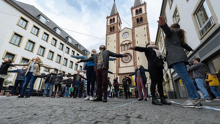 Um die 50 Menschen führten am Domplatz in Würzburg ein ihnen unbekanntes Theaterstück auf.