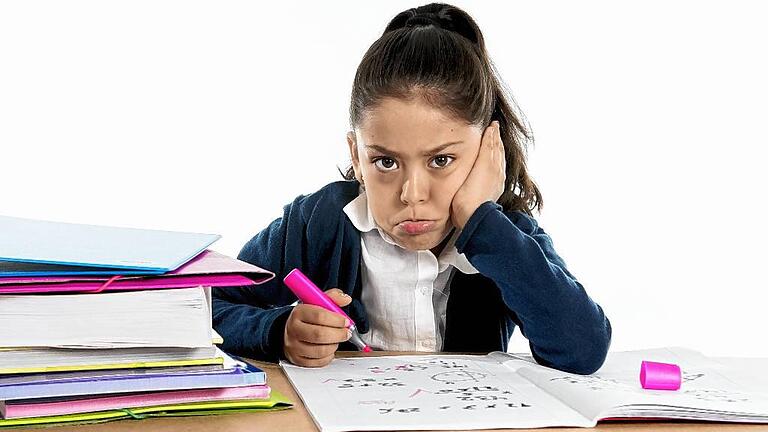 hispanic school girl bored in stress with upset face expression       -  Zu viel ist zu viel: In Spanien proben Schüler und Eltern den Aufstand gegen die aus ihrer Sicht zu vielen Hausaufgaben.