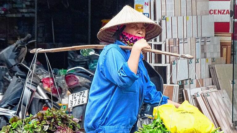 Frühmorgens läuft diese Vietnamesin durch die Stadt, um ihr frisches Gemüse an den Mann zu bringen.