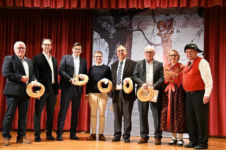 Eine liebgewordene Tradition des Heimat- und Trachtenvereins ist die Überreichung von Neujahrskringeln und einem Gedichtes während des Neujahrsempfangs der Marktgemeinde (von links): Zweiter Bürgermeisterstellvertreter Bernhard Hupp, Erster Bürgermeisterstellvertreter Sven Winzenhörlein, Bürgermeister Alexander Knahn, Diakon Dennis Stephan, Pfarrer Matthias Lotz, Altbürgermeister Peter Stichler sowie Jutta Mackh und Klaus Kempf vom Heimat- und Trachtenverein. Eine liebgewordene Tradition des Heimat- und Trachtenvereins ist die Überreichung von Neujahrskringeln und einem Gedichtes während des Neujahrsempfangs der Marktgemeinde (von links): Zweiter Bürgermeisterstellvertreter Bernhard Hupp, Erster Bürgermeisterstellvertreter Sven Winzenhörlein, Bürgermeister Alexander Knahn, Diakon Dennis Stephan, Pfarrer Matthias Lotz, Altbürgermeister Peter Stichler sowie Jutta Mackh und Klaus Kempf vom Heimat- und Trachtenverein.