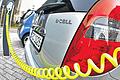 Frische Kraft: Ein Elektroauto wird mit einem gelben Stromkabel an einer Ladesäule geladen.