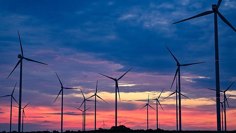 Zur goldenen Stunde, etwa eine Stunde vor Sonnenaufgang, drehen sich die Rotorblätter von Windenergieanlagen im Wind auf diesem Symbolbild in Brandenburg. Die Bürger Üchtelhausens votierten in einem Bürgerentscheid nun klar pro Windkraft in ihrer Gemeinde. Zur goldenen Stunde, etwa eine Stunde vor Sonnenaufgang, drehen sich die Rotorblätter von Windenergieanlagen im Wind auf diesem Symbolbild in Brandenburg. Die Bürger Üchtelhausens votierten in einem Bürgerentscheid nun klar pro Windkraft in ihrer Gemeinde.