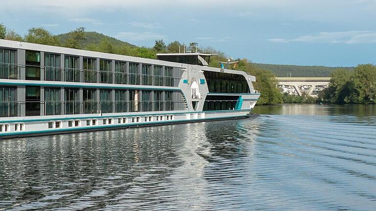 Flusskreuzfahrt auf dem Main       -  Immer häufiger sind größere Flußkreuzfahrtschiffe auf dem Main unterwegs. Auf dem Bild kreuzt gerade die MS Anesha bei Hofstetten den Weg der Hofstettener Fähre und fährt mainaufwärts in Richtung Gemünden, Würzburg und vermutlich über den Rhein-Main-Donau-Kanal in die Donau.