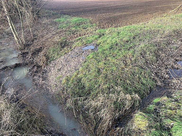 Über einen Feldweg ergoss sich das Abwasser in den vorbeifließenden Lachgraben. Der Bach mündet in die Wern. Über einen Feldweg ergoss sich das Abwasser in den vorbeifließenden Lachgraben. Der Bach mündet in die Wern.