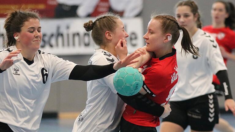 Handball aus Bad Brückenau - Zähes Ringen im Abstiegskampf: Mareike Schneider vom FC Bad Brückenau (rotes Trikot) behauptet den Ball leidenschaftlich gegen den TV Großlangheim. Handball aus Bad Brückenau - Zähes Ringen im Abstiegskampf: Mareike Schneider vom FC Bad Brückenau (rotes Trikot) behauptet den Ball leidenschaftlich gegen den TV Großlangheim.