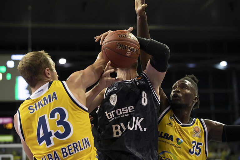 Umkämpftes Spiel: Die Berliner Luke Sikma und Landry Nnoko stoppen den Würzburger Johannes Richter - wenn auch nicht ganz regelkonform.